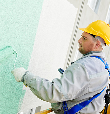 painter with hard hat roller with green paint